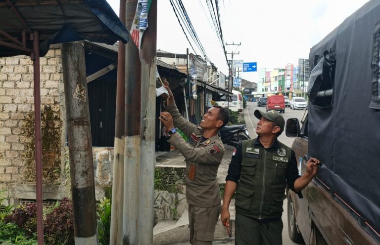 Anggota Satpol PP Kecamatan Caringin Tertibkan Spanduk Tanpa Izin